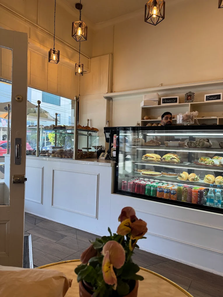 Warm interior seating and pastry cabinet at Provence Bakers